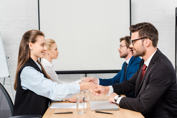 two teams of business people shaking hands during meeting at modern office - Фото, изображение