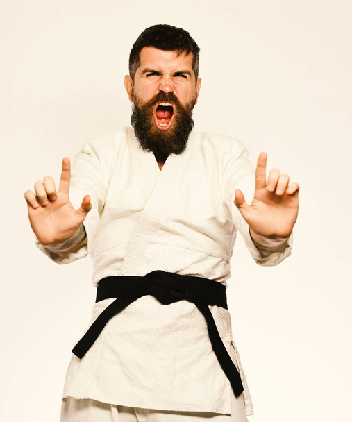 Karate man with angry face in uniform. Oriental sports concept. Jiu Jitsu master with black belt - Φωτογραφία, εικόνα