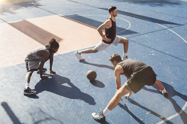 Group of basketball teammates doing stretching exercises together. - Fotografie, Obrázek