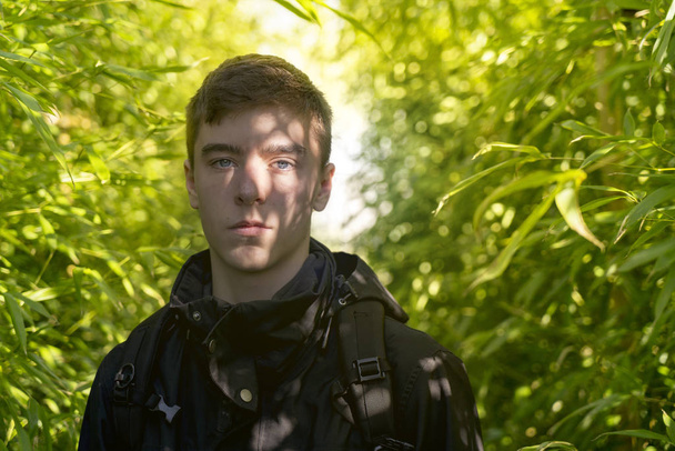 портрет молодого человека с тенями бамбукового леса на лице
 - Фото, изображение