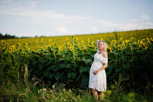 Ayçiçeği alanındaki sarışın hamile anne. Gebeliğin mutlu anları. - Fotoğraf, Görsel