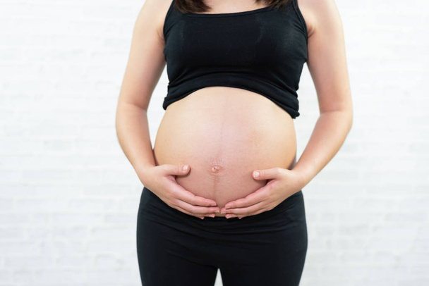 Nahaufnahme von einem süßen Schwangerschaftsbauch - Foto, Bild