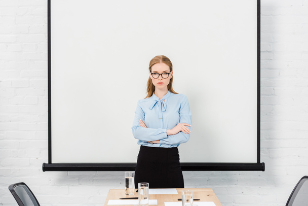 confident young businesswoman with eyeglasses at conference hall looking at camera - Fotografie, Obrázek