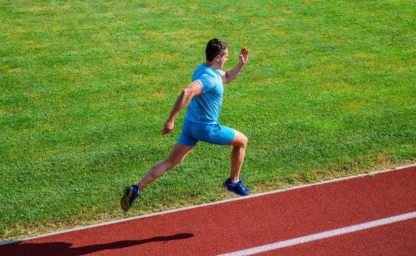 Athlete run track grass background. Sprinter training at stadium track. Runner captured in midair. Short distance running challenge. Boost speed. Run into shape. Running challenge for beginners - Photo, Image