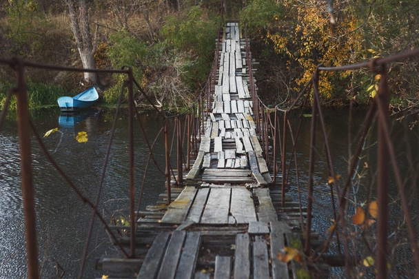 Vieux pont en bois abandonné traversant la rivière, fond sombre
 - Photo, image