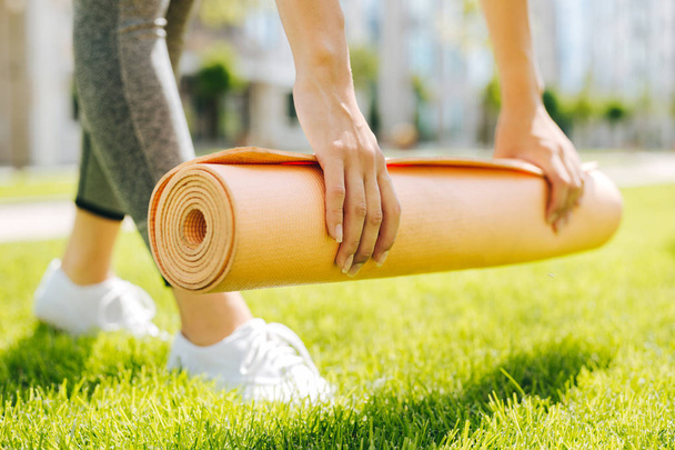 Yoga mat being put on the grass - Foto, imagen