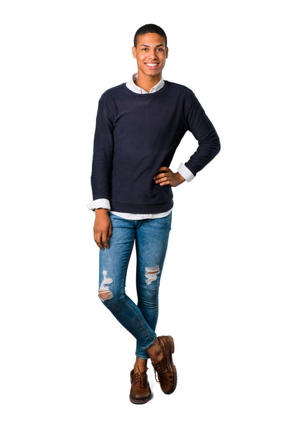 Joven afroamericano posando con los brazos en la cadera y riendo mirando al frente sobre un fondo blanco aislado. Ideal para su uso en diseños arquitectónicos
 - Foto, Imagen