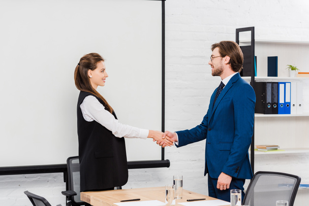 successful young business colleagues shaking hands during meeting - Foto, imagen