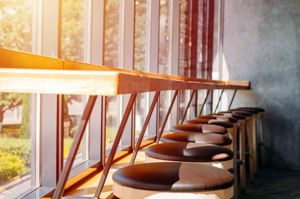 interior cafe. Bar stools stand in row near large window - Photo, Image