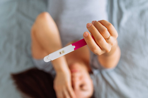 smutna kobieta na łóżku z ujemnego wyniku testu ciążowego - Zdjęcie, obraz
