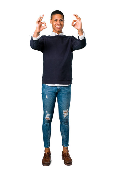 Young african american man showing an ok sign with fingers. Face of happiness and satisfaction on isolated white background - Foto, afbeelding