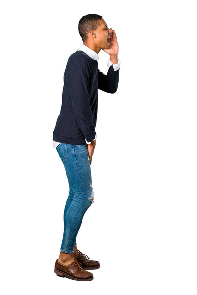 Young african american man shouting with mouth wide open and announcing something on isolated white background - Photo, Image