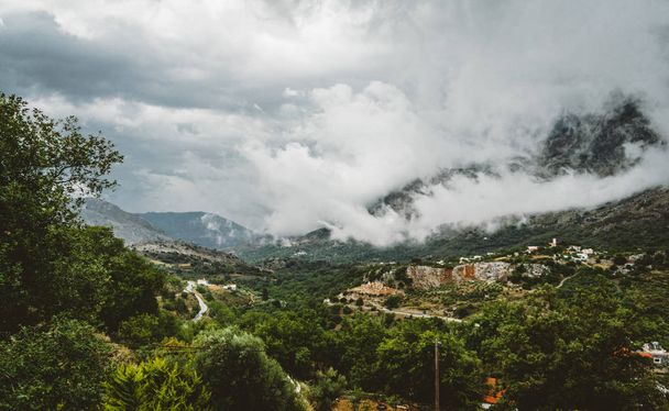 Vista sobre la montaña con nubes bajas y árboles verdes. Creta del Sur aseado Rethymno, Grecia
 - Foto, imagen