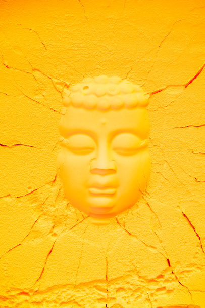 top view of buddha head shape on orange flour texture with cracks - Foto, Imagen