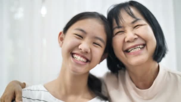 4k close-up lachende gezicht van gelukkig Aziatisch meisje knuffelen haar grand moeder, Multi generatie van Aziatische vrouwelijke, 60 fps - Video