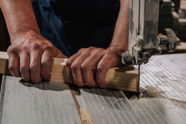 vista parcial del carpintero utilizando taladro eléctrico sobre madera en el taller
 - Foto, Imagen