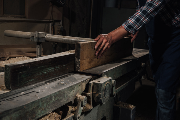 cropped shot of carpenter working with wood at workshop - Photo, Image