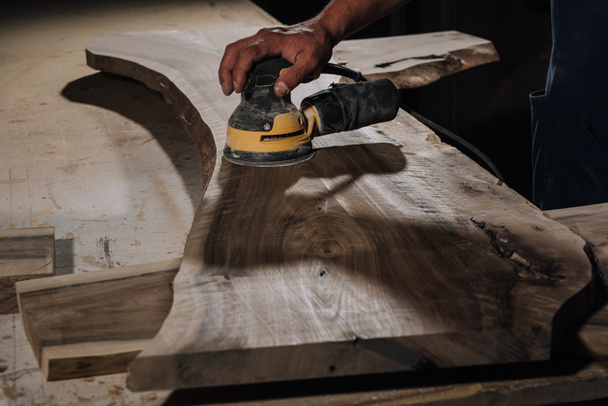 vista parcial del carpintero trabajando con plano eléctrico en taller
 - Foto, Imagen