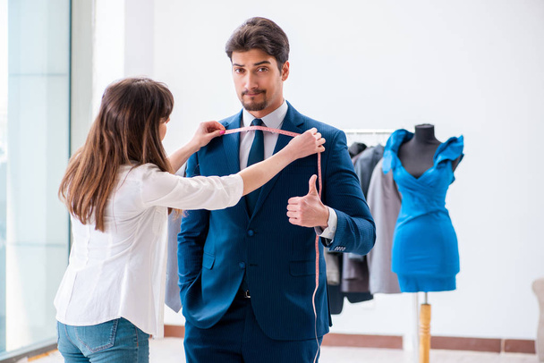 Professioneller Maßschneider nimmt Maß für formalen Anzug - Foto, Bild
