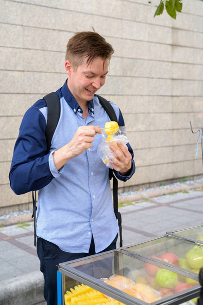 Nuori onnellinen turisti mies backpacker ostoksia kadulla markkinoilla
 - Valokuva, kuva