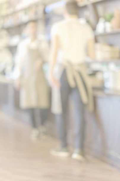 Two unrecognizable waiter in a cafe at work. Light abstract background - 写真・画像