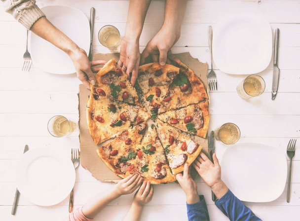 four hands taking pieces of pizza - Foto, Bild