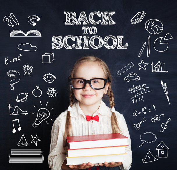 Smiling child little girl in class room with blue chalkboard. Back to school. - Fotografie, Obrázek