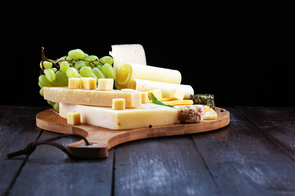 Kaasschotel met verschillende kaas en druiven - Foto, afbeelding