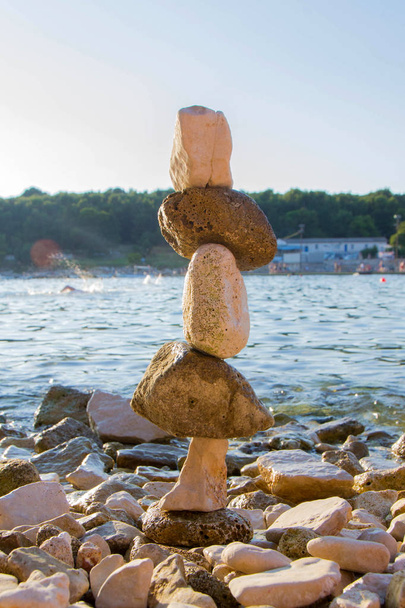 Пирамида морских камней на гальке морского берега. Морской пейзаж. Концепция баланса и духовности. - Фото, изображение