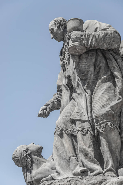 Statues at Marian Column or Holy Trinity at Hradcanske Square for bubonic plague epidemics in Prague, Czech Republic, portrait, details, blue gradient sky - Photo, Image