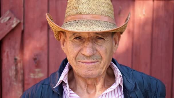 Porträt eines älteren Bauern mit Strohhut auf einem Bauernhof. Gesicht eines Mannes im Alter - Filmmaterial, Video