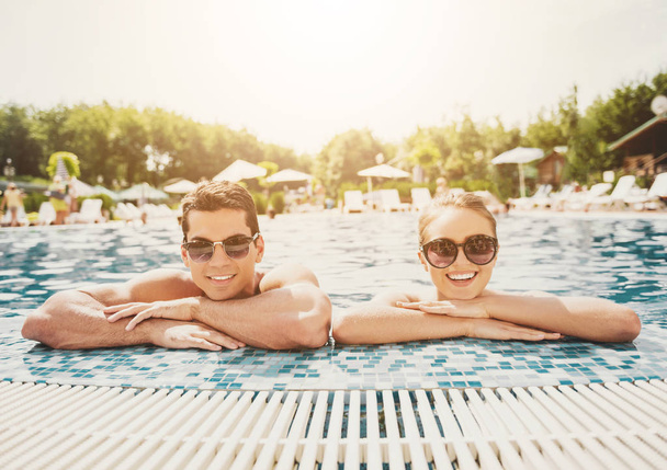Young Smiling Couple in Swimming Pool in Summer. - Zdjęcie, obraz