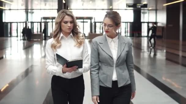 Baş ve yardımcı bir ofis binası içinde. iki iş kadınları iş merkezi koridor yürüyüş - Video, Çekim