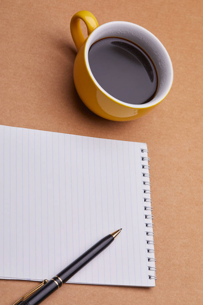 чашка кави з блокнотом і ручкою на офісному столі
 - Фото, зображення