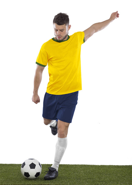 Young soccer fan with yellow and green shirt playin soccer with emotion on white background - Foto, immagini