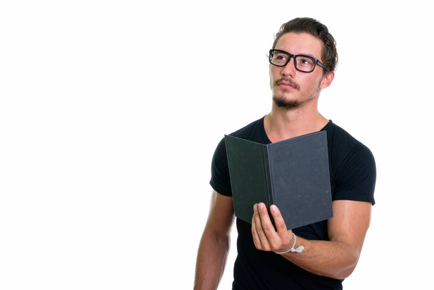 Studio colpo di giovane bell'uomo in possesso di libro mentre si pensa wi
 - Foto, immagini