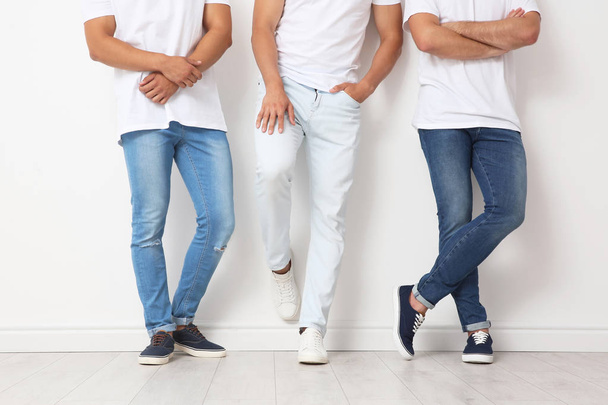 Group of young men in jeans near light wall - Foto, Bild