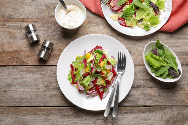 Delicious beet salad on wooden table, top view - Foto, imagen
