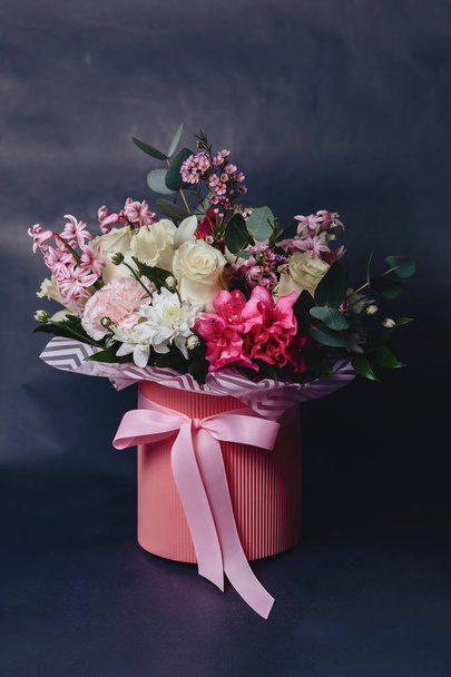 colored flower bouquet in basket on dark background - Fotó, kép
