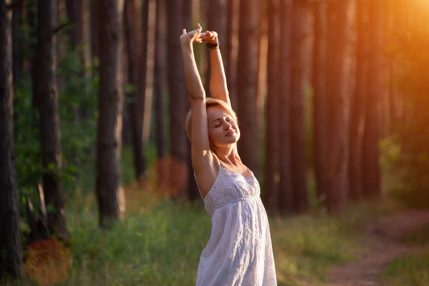 beautiful pregnant girl in the forest raises her hands to the sky - Photo, image