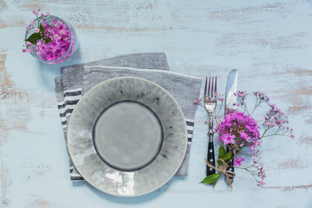 Rustic table setting with pink flowers on light wooden table. Holidays decoration on Provence style. Romantic dinner. Top view with copy space for text - Photo, Image