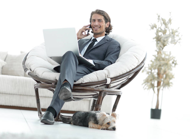 business man talking on a smartphone sitting in the living room - Фото, зображення