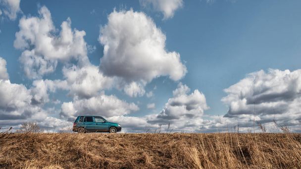 Groene auto op een bewolkte hemelachtergrond - Foto, afbeelding