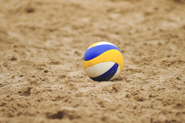 Pallavolo giallo e blu nella sabbia
 - Foto, immagini