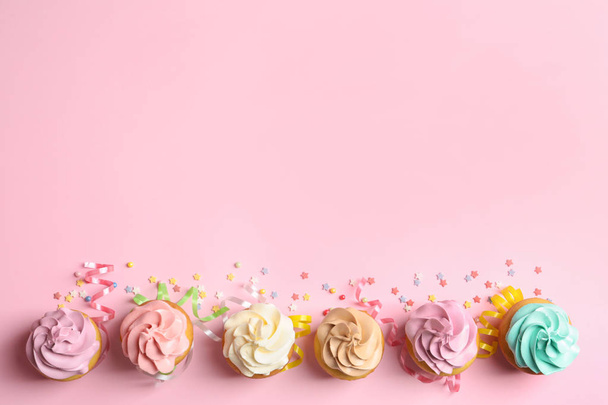 Flat lay composition with delicious birthday cupcakes and space for text on color background - Foto, Imagen
