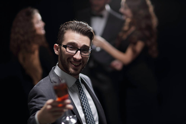 елегантний чоловік піднімає келих шампанського
 - Фото, зображення