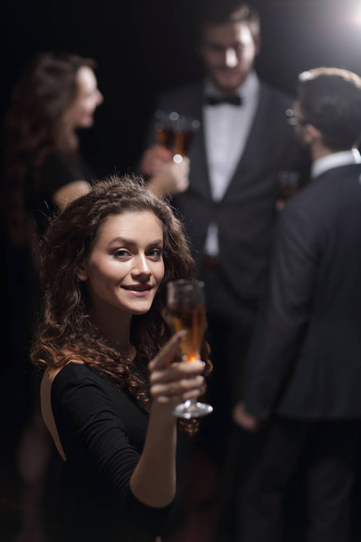 stylish young woman raising a glass of champagne - Fotoğraf, Görsel