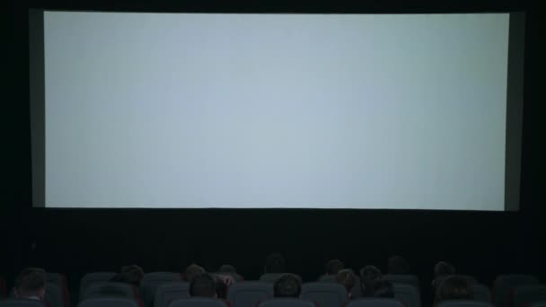 Los espectadores aplauden en previsión de la sesión de cine frente a la pantalla blanca
 - Imágenes, Vídeo