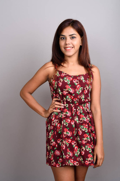 Νέοι όμορφη ινδική γυναίκα που φοράει φόρεμα εναντίον γκρι λεμονάτα - Φωτογραφία, εικόνα