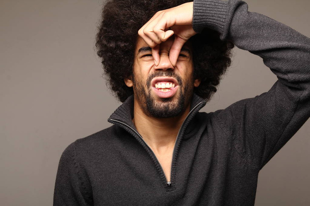Black man with curly hair smelling  - Foto, afbeelding